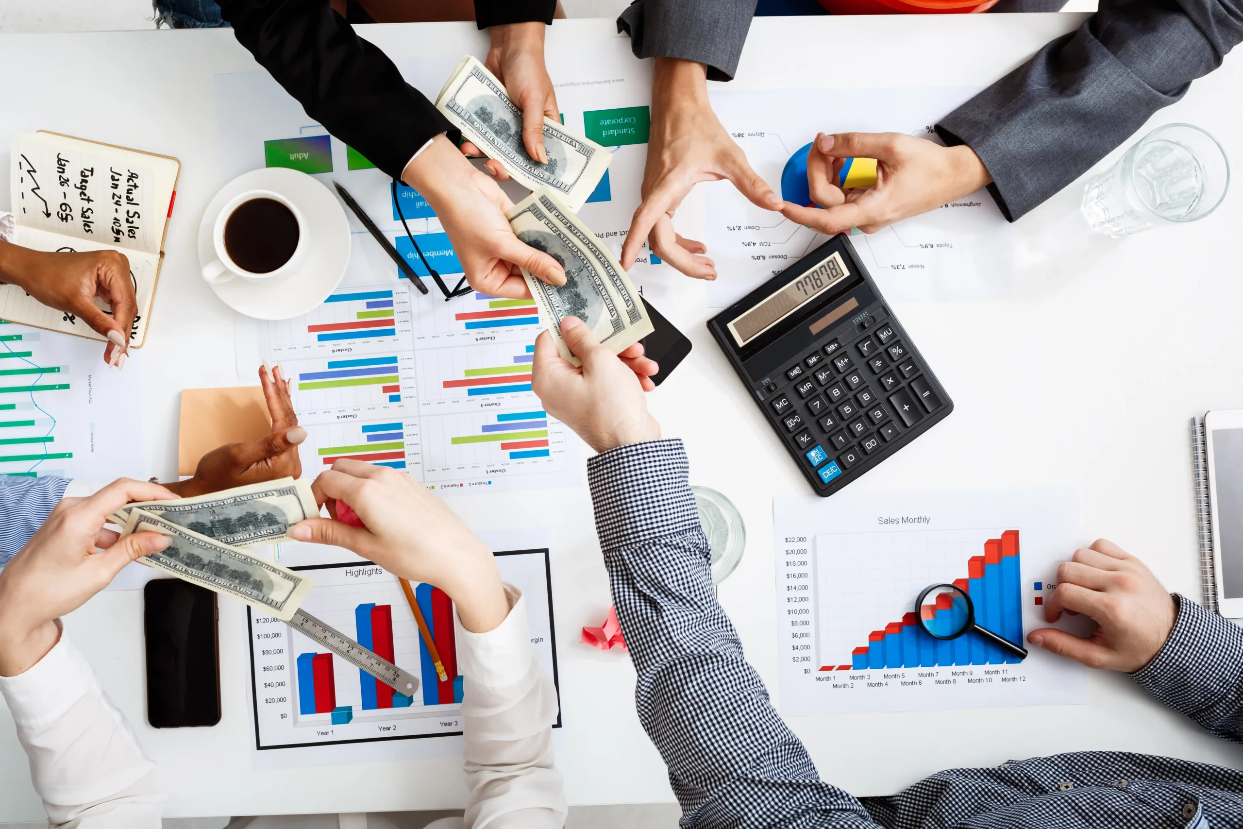 Businessmen’s hands on white table with documents and drafts